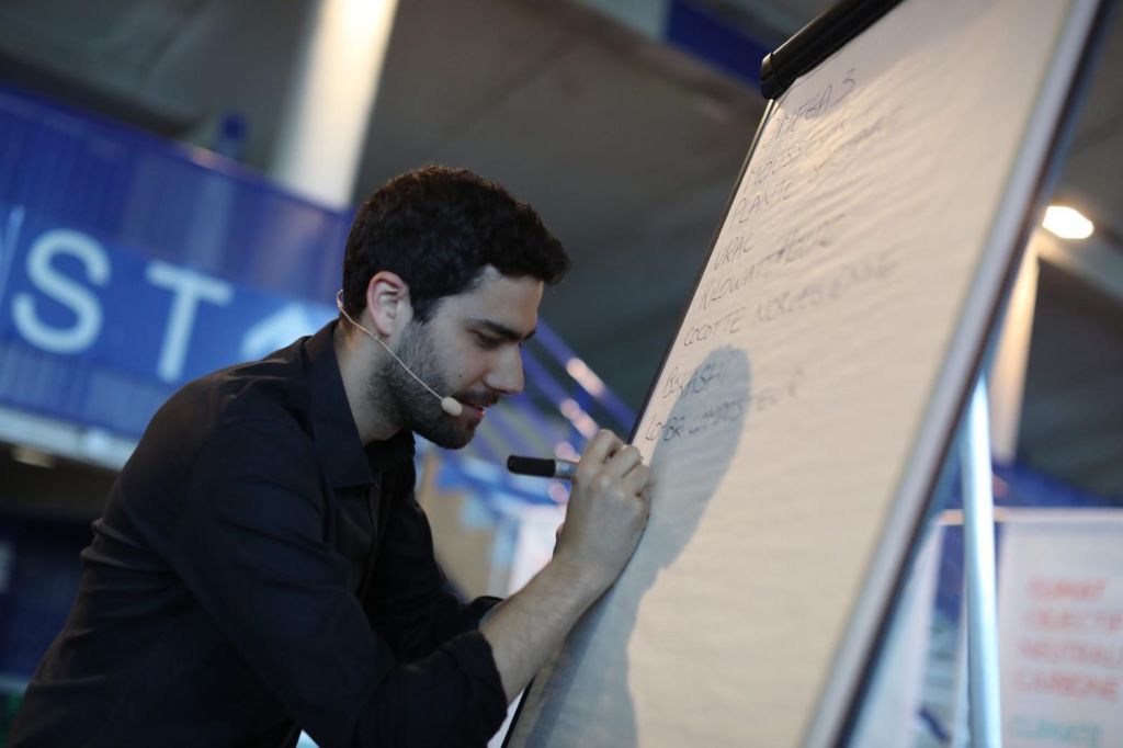 Lucas Prost écrivant sur un paperboard en animation de séminaire au Zénith de Nantes en mai 2022